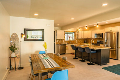 Modern kitchen and dining area with wooden table and chairs.